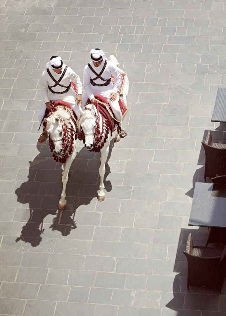 Souk Waquif, Doha, Qatar. Mounted guard horses, riding through Souk Waquif afternoon